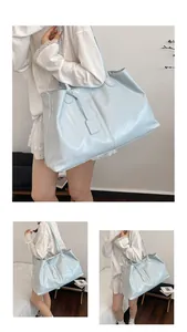 Detail showing high-gloss light blue faux leather texture and stitching of large tote bag