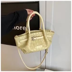 Vue détaillée du sac seau tressé jaune crème avec boucle en métal et bandoulière
