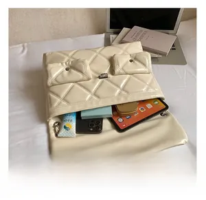 Detail showing the large interior capacity of this cream quilted chain messenger bag