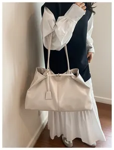 Detail view of cream oversized leather tote bag with elegant pleated design and straps