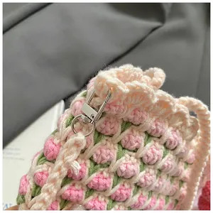 Close-up of hand-woven bucket bag featuring 3D pink tulip patterns and metal clasps
