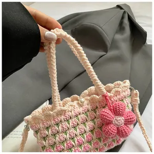 Detail of hand-woven tulip crochet bag with pink floral pattern and pearl button