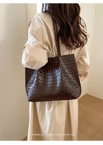 Gros plan détaillé du sac cabas en cuir tressé marron foncé au design rétro minimaliste