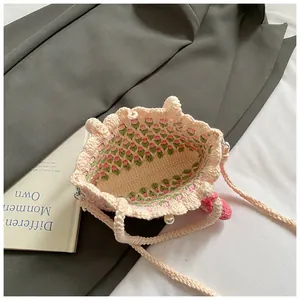 Macro view of woven shoulder bag with tulip flower details and pearl button closure