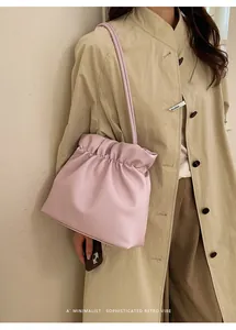 Minimalist soft pink pleated bucket bag shown with a retro vibe for everyday style