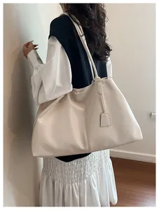 Rear view of model carrying a minimalist creamy white leather tote bag for daily commute