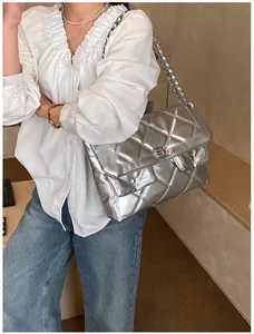Close-up of silver quilted crossbody bag featuring metal chain and double ring lock