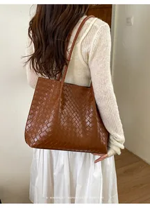 Détail du cabas en cuir tressé marron foncé montrant la texture fine et le style rétro épuré