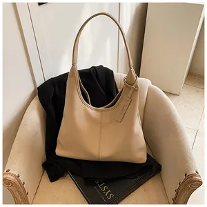 Gros plan du sac hobo beige en cuir grainé litchi avec étiquette CHERIMATE sur chaise