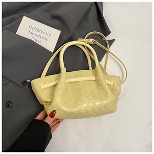 Détail du sac à main tressé jaune clair montrant la texture et la bandoulière réglable