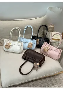 Close-up of minimalist faux leather tote bags in five colors with cute bear pendants