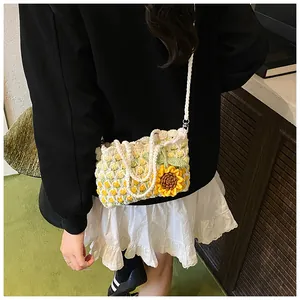 Detail view of woven sunflower shoulder bag with white pearl button and crochet texture