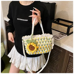 Close-up of handmade woven sunflower bucket bag with pearl clasp and mesh texture
