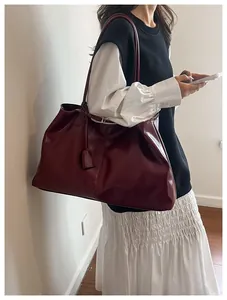 Deep red large capacity leather tote bag worn by a model for professional daily commute