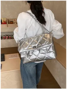 Detailed shot of large silver quilted bag featuring triple flap design and chain strap