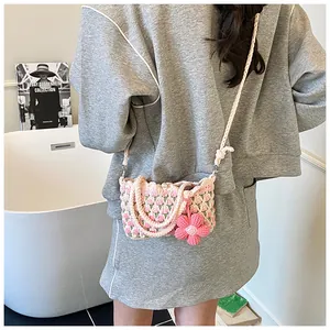 Close-up of pink and green crochet tulip shoulder bag with oversized floral pendant charm