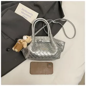 Détails du sac seau tressé argenté avec breloque ours et fine bandoulière chic