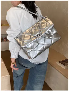 Detail of silver quilted chain bag featuring metallic texture and large diamond stitching