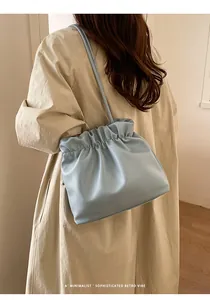 Close-up of light blue cloud bag with delicate pleats and a minimalist retro vibe