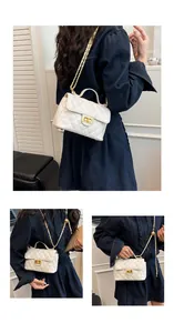 Vue macro d'un sac à rabat matelassé blanc avec chaîne dorée et fermoir rotatif en métal