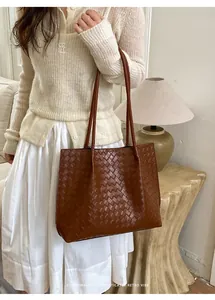 Gros plan du sac cabas en cuir tressé marron foncé avec texture rétro élégante