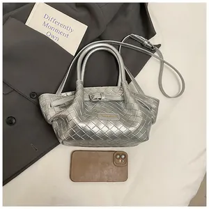 Détail du sac seau tissé argenté avec texture métallique et plaque logo CHIKIMATE