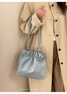 Minimalist light blue drawstring bucket bag with soft pleated design and slim strap