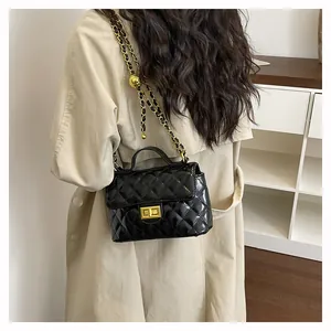 Détail du sac bandoulière matelassé noir avec chaîne dorée et fermoir en métal