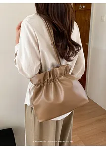 Brown pleated bucket bag on model featuring a minimalist retro style and large capacity