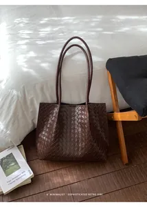 Vue détaillée du cuir tressé marron foncé sur un grand sac cabas rétro minimaliste