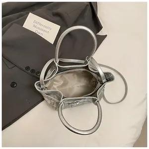 Vue intérieure du sac seau tressé argenté montrant la doublure et la poche zippée