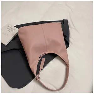 Gros plan du sac cabas rose grainé avec couture verticale et détail de l'étiquette
