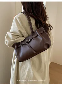 Detailed view of dark brown soft leather tote bag with silver buckle and retro vibe