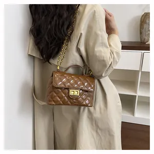 Mannequin avec sac bandoulière marron matelassé, chaîne dorée et fermoir pivotant