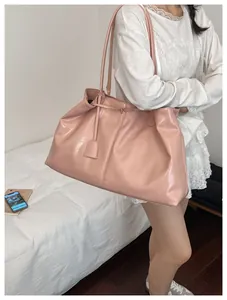 Macro detail of glossy pink leather tote bag with elegant matching mini hanging pouch
