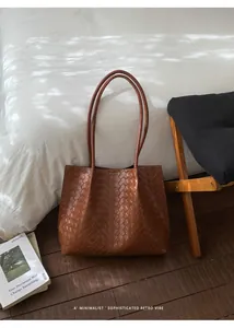 Détail du grand sac cabas en cuir tressé marron avec de fines bandoulières en cuir