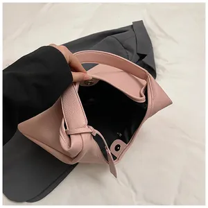 Vue détaillée du sac rose avec texture grainée, fermoir magnétique et doublure noire