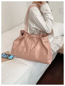 Pink large capacity faux leather tote bag being worn in a bright indoor lifestyle setting