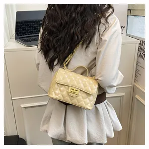 Détail du sac bandoulière beige matelassé avec fermoir doré et bandoulière en chaîne
