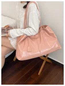 Macro shot of large pink tote bag showing glossy leather texture and stylish thin handles
