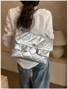 Detailed view of silver quilted chain crossbody bag showing metallic texture and rotary lock