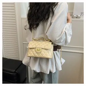 Détail du sac à bandoulière matelassé beige avec fermoir doré et texture en cuir