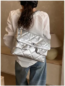 Silver quilted chain crossbody bag shown on model highlighting the size and shiny metallic finish