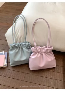 Detailed view of minimalist retro drawstring bucket bags in pastel pink and mist blue