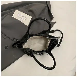 Vue intérieure du sac seau noir tissé avec poche zippée et doublure spacieuse