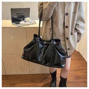 Detailed shot of a black glossy tote bag with soft leather texture and stylish thin straps