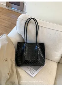 Détail de la texture tissée noire sur un grand cabas minimaliste en cuir pour femme