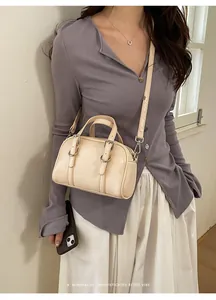 Mini borsa Boston beige chic abbinata a maglione viola e gonna bianca da donna