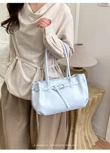 Sky blue soft leather tote bag detail with decorative belt buckle and shoulder strap