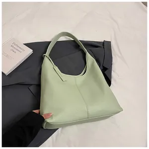 Détail de la texture cuir grainé litchi sur le grand sac hobo de couleur vert clair